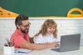 Back to school. Teacher and pupil boy learning at laptop computer, studying with online education e-in the classroom. Royalty Free Stock Photo