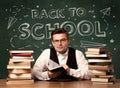 Back to school teacher sitting at classroom desk