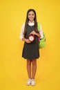Back to school. Teenage school girl with bag hold clock alarm, time to learn. Schoolgirl on isolated yellow background Royalty Free Stock Photo
