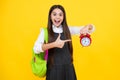 Back to school. Teenager schoolgirl with bag hold clock alarm, time to learn. School children on isolated yellow Royalty Free Stock Photo