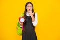 Back to school. Teenager schoolgirl with bag hold clock alarm, time to learn. School children on yellow