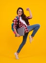 Back to school. Teenager schoolgirl hold notebook laptop. School children on  yellow studio background. Run and Royalty Free Stock Photo