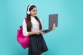 Back to school. Teenager schoolgirl in school uniform with bagpack, headphones and laptop. School children on isolated Royalty Free Stock Photo