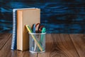 Stand with pencils, books, on a wooden table