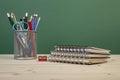 Back to school template with stationeries and books on table over green Royalty Free Stock Photo