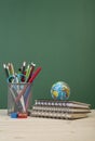 Back to school template with stationeries and books on table over green Royalty Free Stock Photo