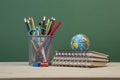 Back to school template with stationeries and books on table over green Royalty Free Stock Photo