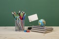 Back to school template with stationeries and books on table over green Royalty Free Stock Photo