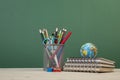 Back to school template with stationeries and books on table over green Royalty Free Stock Photo