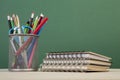 Back to school template with stationeries and books on table over green Royalty Free Stock Photo