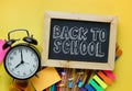 Back to School Text. Alarm Clock, Blackboard and School Stationary on Yellow Background Royalty Free Stock Photo