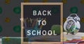 Back to school text on black board against color palette and geometrical instruments icon