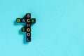 Back to school text from colorful letters on black cubes laid out in form of crossword puzzle, blue background. Concept education