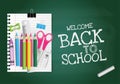 Back to school text on green chalkboard with alarm clock, crayon, notepaper, pencil, chalk