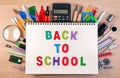 Back to school text on notebook over school supplies or office s Royalty Free Stock Photo