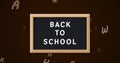 Back to school text on slate against multiple changing alphabets on black background