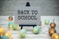 Back to School text on white brick wall and wooden background Royalty Free Stock Photo