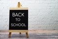 Back to School text on wooden Easel on white brick wall background