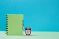 Back to school. Time to study. New school year concept. Notebook and red alarm clock on blue background, copy space Royalty Free Stock Photo