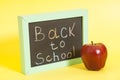 Back to School written on a chalkboard and red apple Royalty Free Stock Photo