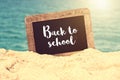 Back to school written on a vintage chalkboard in the sand of a beach Royalty Free Stock Photo