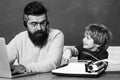 Back to school. Young boy doing his school homework with his father. Teacher helping kids with their homework in