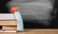 Back to virtual school background concept with stack of books and apple with face mask Royalty Free Stock Photo