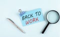 BACK TO WORK text written on a sticky with magnifier and pen, business concept Royalty Free Stock Photo
