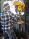 Back turned Caribbean welder working in the French West Indies. Carpentry workshop with saws, drills, woodworking tools.