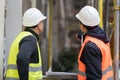 Back turned workers with protective work wear talking on construction site Royalty Free Stock Photo