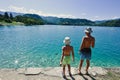 Back of two brothers in panamas stand in pier of view beautiful Bled Lake, Slovenia