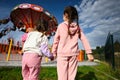 Back of two little girls holding hands and playing at amusement park. Children having fun outdoors merry-go-round Royalty Free Stock Photo