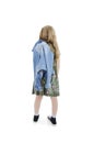 Back view of adorable modern little girl holding denim jacket looking at wall. Rear view. Royalty Free Stock Photo