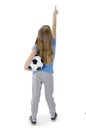 Back view of adorable teenage girl holding football, points at wall. Rear view. Isolated on white background. Royalty Free Stock Photo