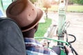 Back view of African worker driving heavy construction equipment backhoe