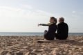 Back view of aged couple sitting on surfboard Royalty Free Stock Photo