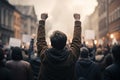 Back view of angry protesters raising fists in city demonstration