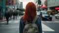 Back view of anonymous female with red hair standing near crosswalk