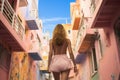 Back view of anonymous young woman walking on a cobblestone colorful street