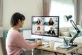 Back view of Asian business woman talking to her colleagues about plan in video conference. Multiethnic business team using Royalty Free Stock Photo