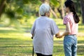 Back view of asian child girl hand holding her senior grandmother, walking together outside home,family time,old elderly taking a Royalty Free Stock Photo