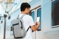 Back view asian guy tourist checking his e-ticket on phone Royalty Free Stock Photo