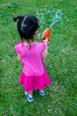 Back view of asian lovely girl playing on green grass. Outdoor Royalty Free Stock Photo