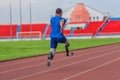 Back view of Asian male athlete with prosthetics sprints, aiming for record at speed running practice