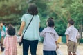 Back view of Asian mother leads her daughter to school.