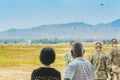 Back view of Asian parents look with worry and concern during parachute training from airplane for army cadet with blurred image Royalty Free Stock Photo