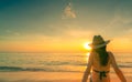 Back view of Asian woman wear bikini and straw hat sit on sand beach relax and enjoy holiday at tropical paradise beach. Woman Royalty Free Stock Photo