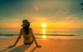 Back view of Asian woman wear bikini and straw hat sit on sand beach relax and enjoy holiday at tropical paradise beach. Woman Royalty Free Stock Photo