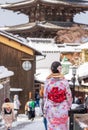 A asian young women wearing Japanese traditional kimono at Sannen-zaka street with snow in winter. Kyoto, Japan. Royalty Free Stock Photo