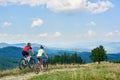 Back view of athlete couple cyclists in sportswear and helmets cycling cross country bikes